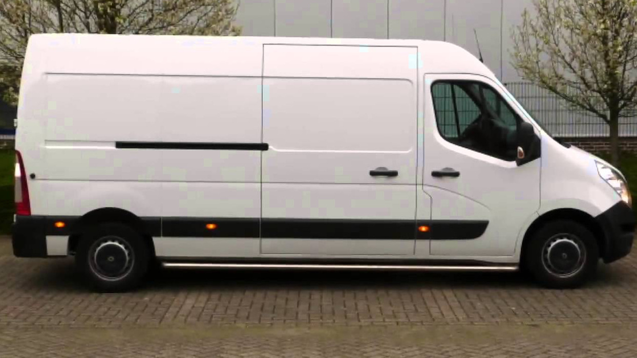 Biały, dostawczy bus Renault Master z przesuwnymi drzwiami bocznymi, zaparkowany na kostce brukowej, widok z boku.