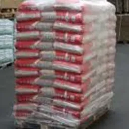 Paleta z workami pelletu Lava 8 mm, owinięta folią stretch, widoczna w magazynie na szarym podłożu.