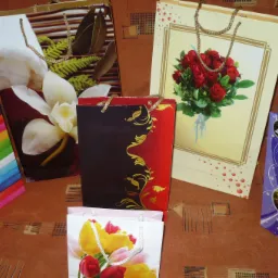 Różnorodne torebki okolicznościowe z motywami kwiatowymi, ułożone na wzorzystym tle.