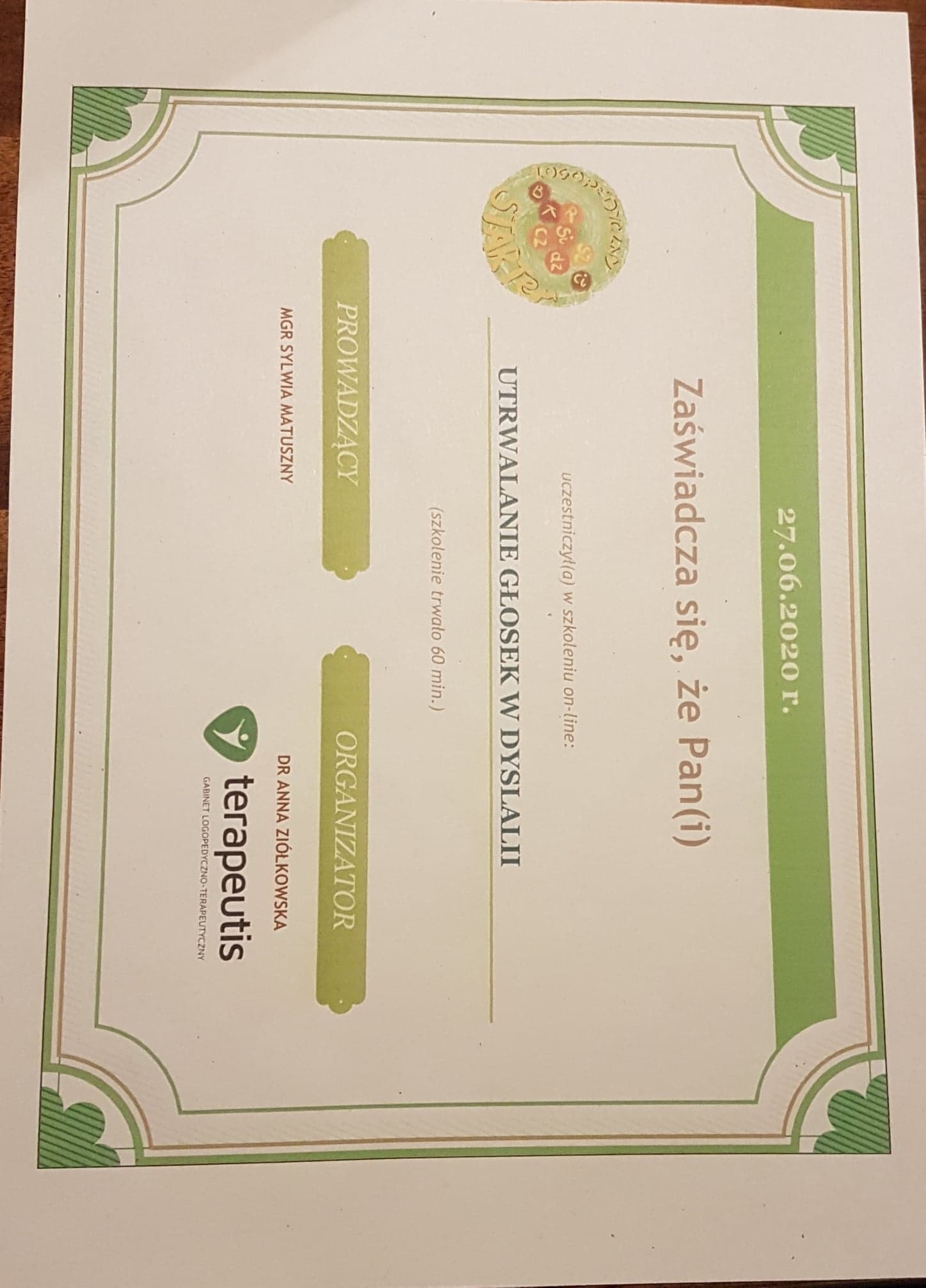 Skan dyplomu ukończenia szkolenia online z utrwalania głosek w dyslalii, z datą 27.06.2020, podpisanego przez prowadzącą mgr Sylwię Matuszny i organizatora dr Annę Ziółkowską, z logo Gabinetu...