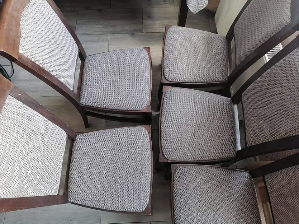 Sześć drewnianych krzeseł z tapicerowanymi siedziskami i oparciami, ustawionych rzędami na podłodze z płytek ceramicznych, widocznych z góry po procesie czyszczenia.