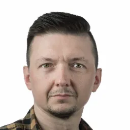 Portret mężczyzny w koszuli w kratę, z krótką brodą i starannie ułożonymi włosami, na białym tle.