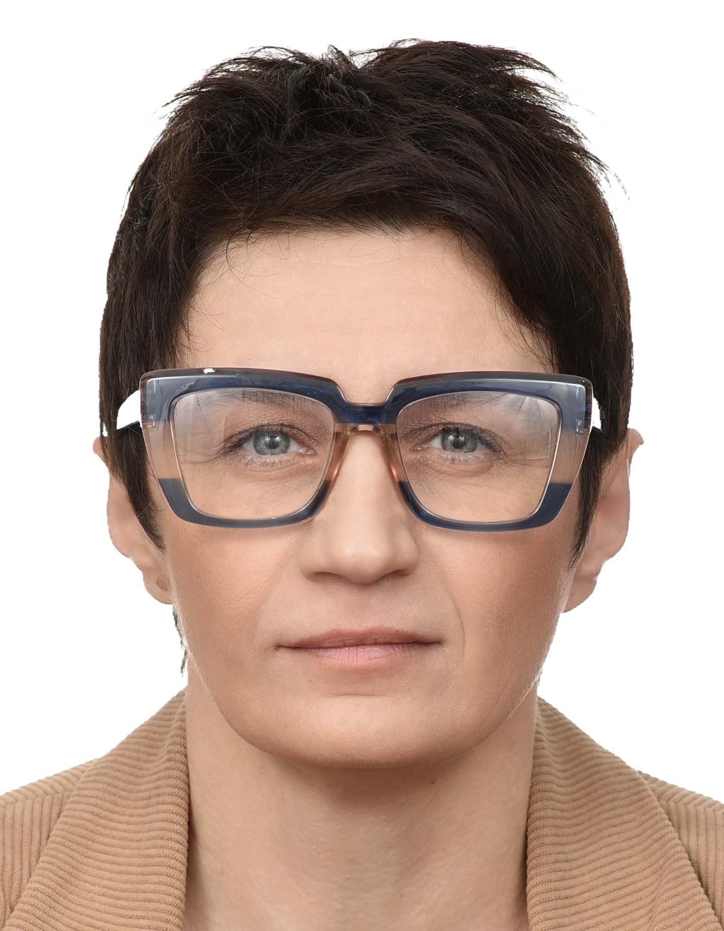 Portret kobiety w okularach o grubych, kwadratowych oprawkach w odcieniach granatu i beżu, na białym tle. Ubrana w beżową kurtkę z prążkowanego sztruksu.