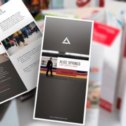 Studio 11 - Stos ulotek i broszur z grafikami i tekstem, na białym tle, widoczne z góry pod kątem.