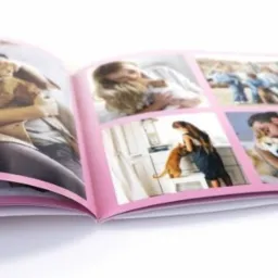 Otwarty album fotograficzny z różowymi ramkami prezentujący kolaż zdjęć ludzi z ich zwierzętami domowymi.