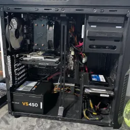 Wnętrze obudowy komputera stacjonarnego z widocznymi komponentami: karta graficzna Gigabyte GeForce GTX, zasilacz Corsair VS450, płyta główna, chłodzenie procesora, dyski twarde (HDD i SSD)...