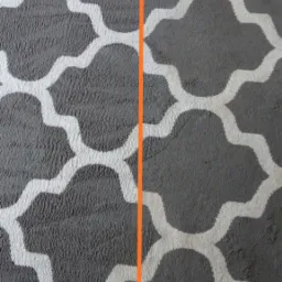 Dywan z szarym wzorem przed i po czyszczeniu, widoczna wyraźna różnica w kolorze i strukturze włókien.