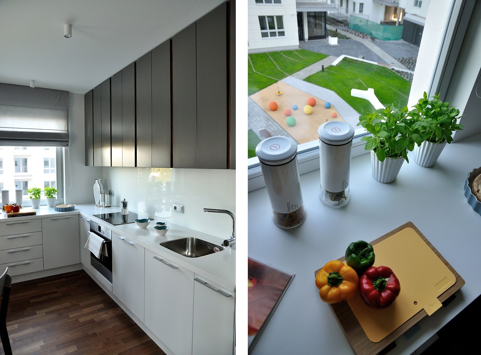 Nowoczesna kuchnia z białymi szafkami dolnymi i szarymi górnymi, drewnianą podłogą, widokiem z okna na plac zabaw oraz detalami dekoracyjnymi na blacie, takimi jak zioła w doniczkach i kolorowa...