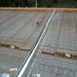 Zbrojenie fundamentu z widoczną szalunką i siatką z prętów zbrojeniowych, przygotowane do wylania betonu, widok z góry.