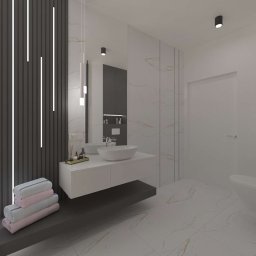 Radwańska Małgorzata Projektowanie Wnętrz - Nowoczesna łazienka z marmurową podłogą i ścianami, wisząca szafka z umywalką, dekoracyjna ściana z oświetleniem LED i stertą ręczników. Minimalistyczny design.