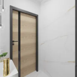 Wizualizacja łazienki z drewnianą okleiną drzwi i marmurową ścianą, widok na umywalkę z blatem z jasnego drewna i złotym dozownikiem, wiszące lampy z przezroczystymi kloszami.