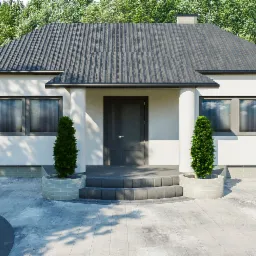 Dom jednorodzinny z szarą kostką brukową na podjeździe i schodach wejściowych, z roślinami w okrągłych donicach po bokach schodów.