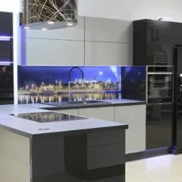 Nowoczesna kuchnia z szarymi i czarnymi frontami, panelem z motywem nocnego miasta nad blatem i czarną lodówką side-by-side z piekarnikiem w zabudowie.