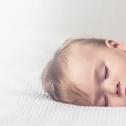 Reklama firmy z Legnicy: Śpiące dziecko wtulone w pluszowego misia, obok czerwony napis 'TerazCieplej kompleksowa obsługa ... śpij spokojnie'.