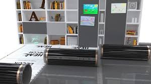 Panele grzewcze na podczerwień w aranżacji wnętrza z regałami, książkami i obrazami na ścianie. Widoczne detale wykończenia paneli.