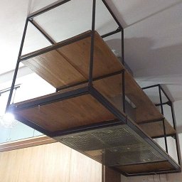 Marcin Birski - Metalowa konstrukcja z drewnianymi półkami zawieszona pod sufitem w kuchni, nad okapem i płytkami ceramicznymi w stylu patchwork