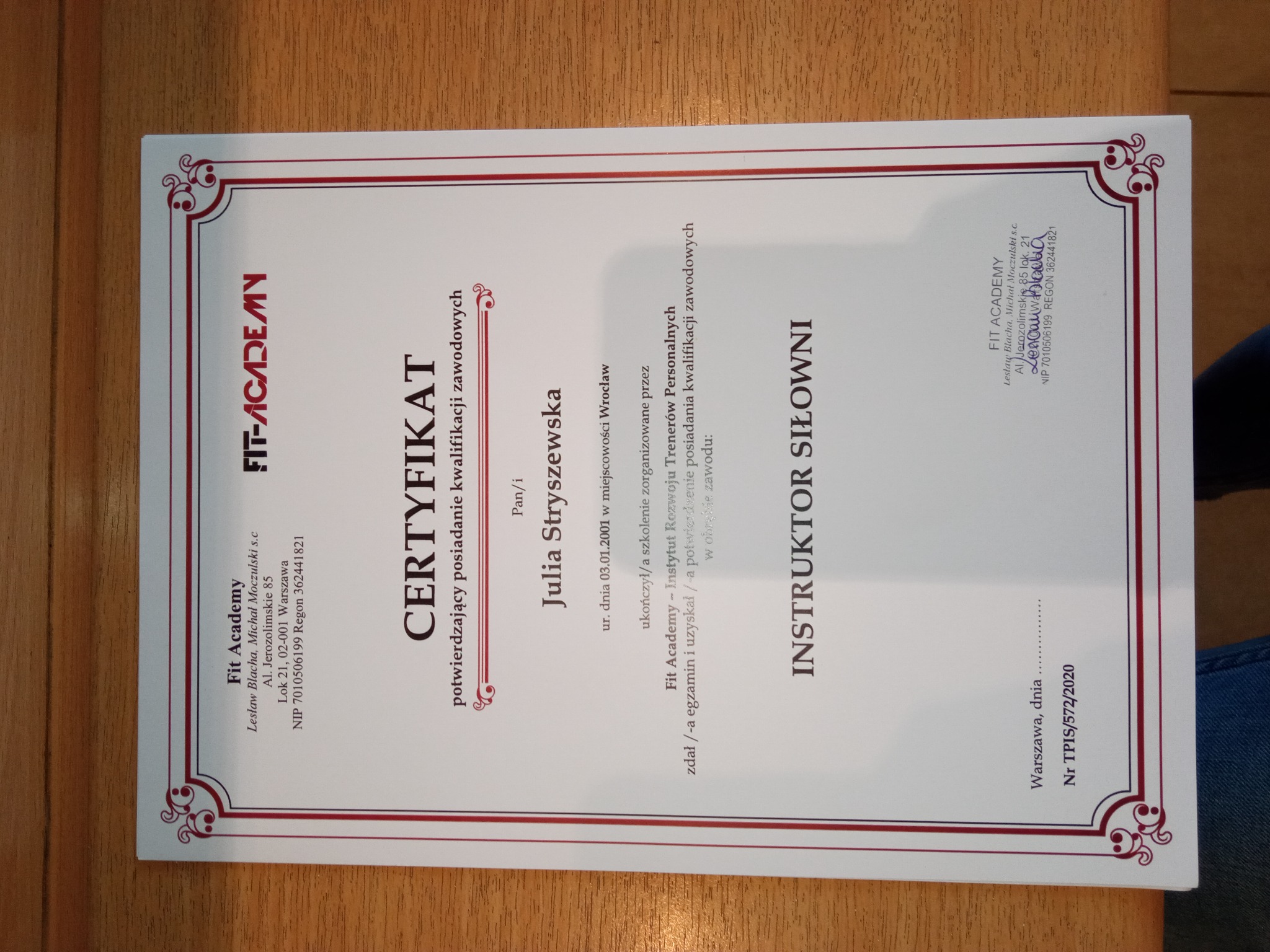 Certyfikat ukończenia szkolenia dla instruktora siłowni, wydany przez Fit Academy dla Julii Stryszewskiej, z ozdobną bordiurą i logo firmy.