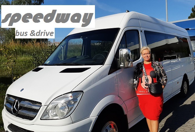 Biały bus marki Mercedes-Benz Sprinter z logo firmy Speedway bus & drive, obok którego stoi uśmiechnięta kobieta w czerwonej sukience.