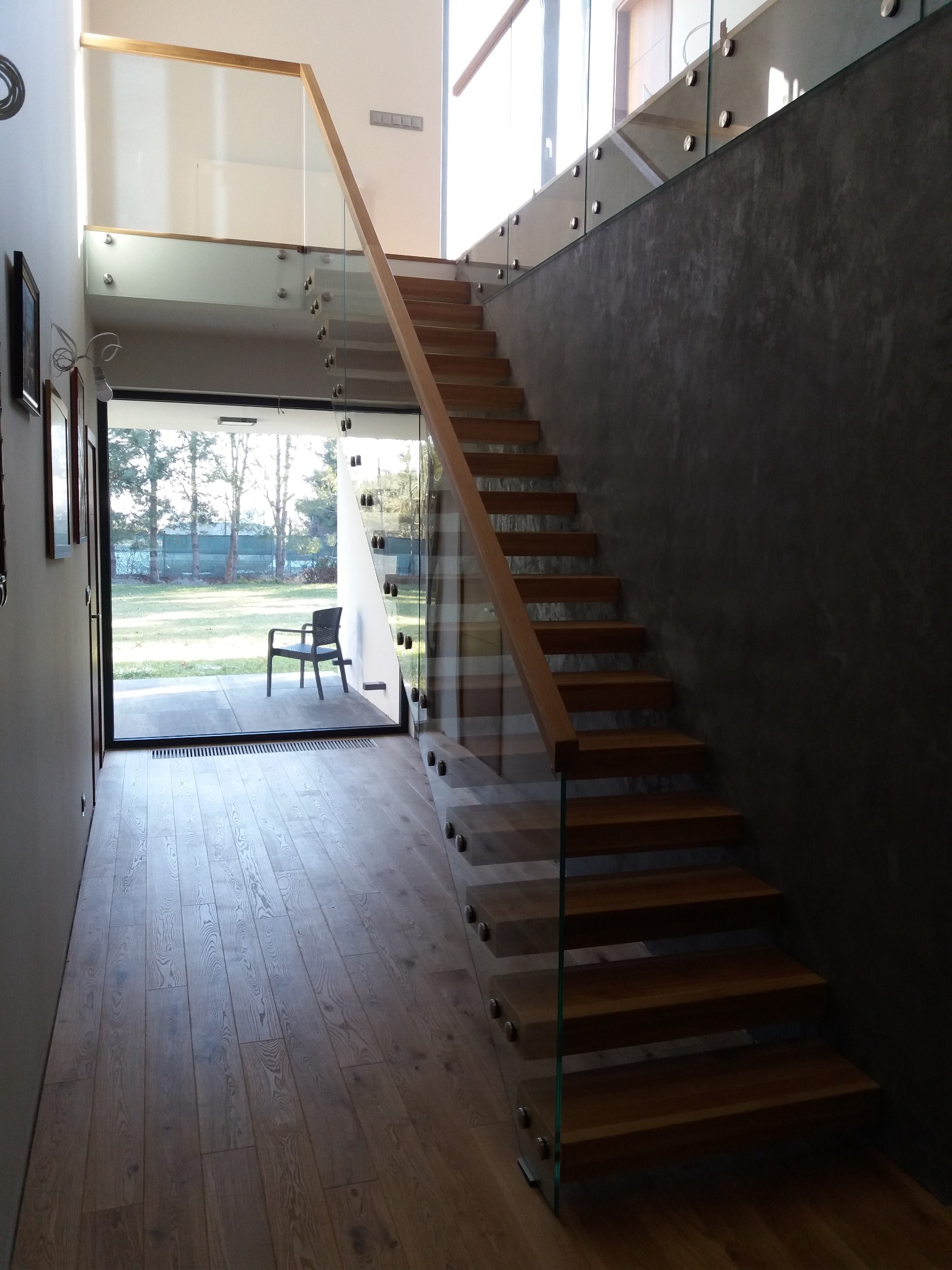 Schody półkowe z balustradą szklaną.