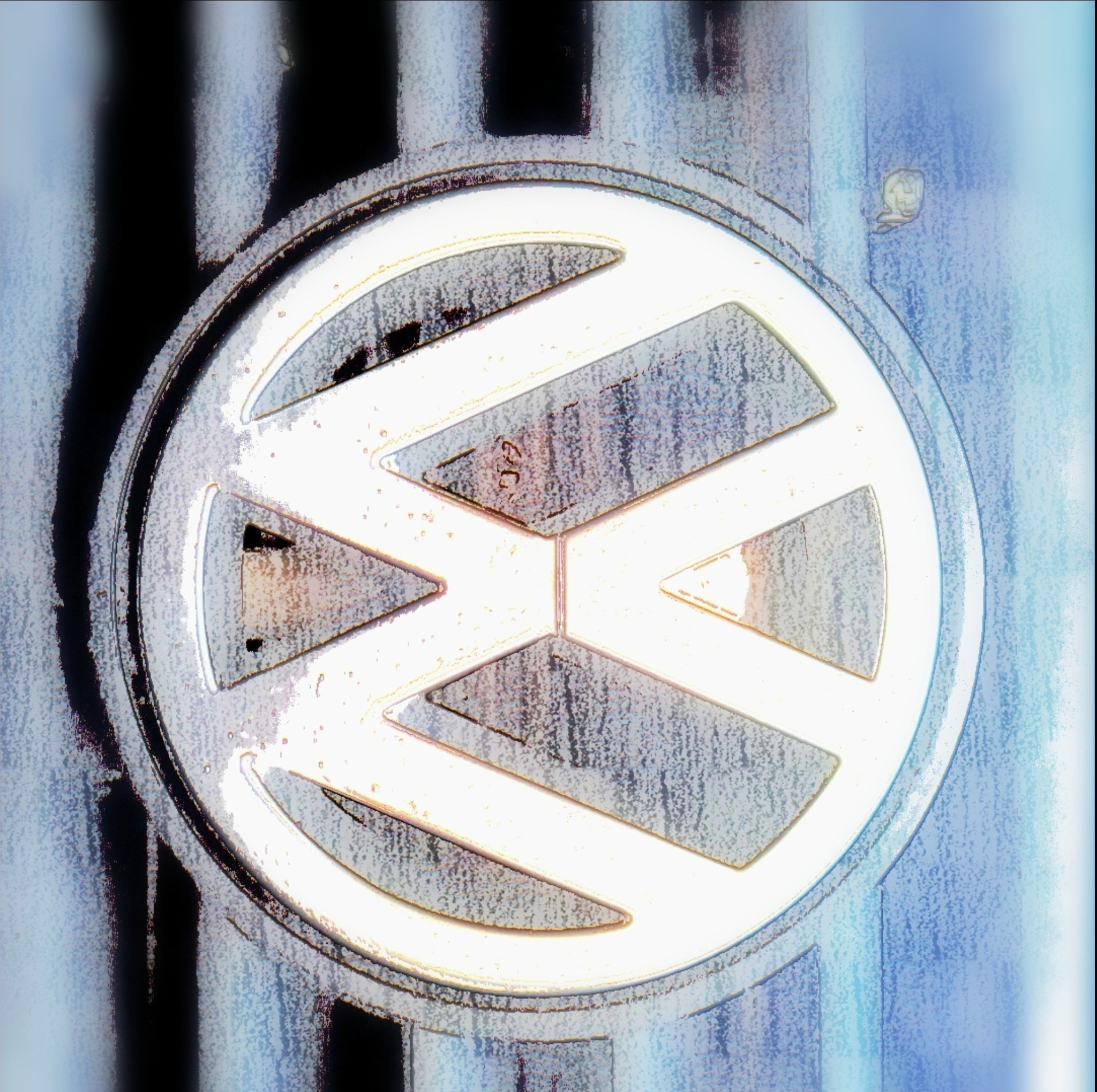 Metalowy emblemat z logo producenta samochodów na boku pojazdu z widocznymi śladami użytkowania i zniekształceniami obrazu.