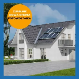 Biały dom jednorodzinny z szarą dachówką, na dachu zamontowane panele słoneczne, z boku domu widoczny taras z meblami ogrodowymi i trawnik, w lewym górnym rogu okrągła pomarańczowa naklejka...