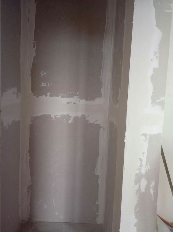 Wnęka ścienna w trakcie wyrównywania gładzią szpachlową, widoczne niedoskonałości i nierówności, przygotowanie pod malowanie.