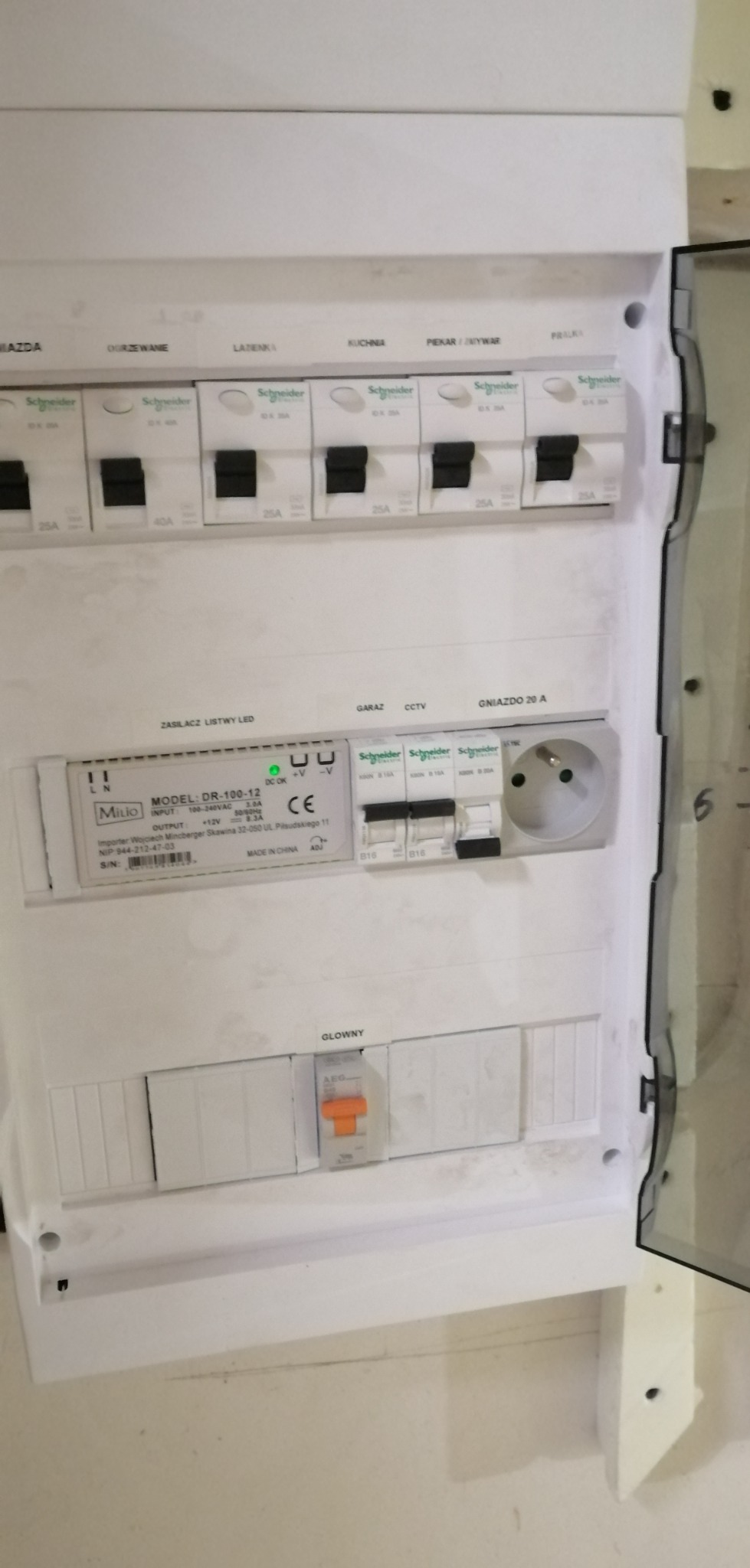 Rozdzielnica elektryczna z bezpiecznikami i zasilaczem listwy LED, zamontowana w Siedlęcinie, widoczne oznaczenia obwodów: Mazda, Ogrzewanie, Łazienka, Kuchnia, Piekarnik/Zmywarka, Pralka.