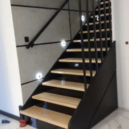 Nowoczesne schody z jasnego drewna i czarną metalową balustradą, oświetlone małymi kwadratowymi lampkami LED w ścianie, na marmurowej podłodze.