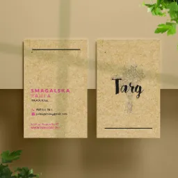 Dwie wizytówki na teksturowanym papierze w odcieniach beżu i brązu, z elementami graficznymi i danymi kontaktowymi, otoczone zielonymi gałązkami pietruszki, rzucające cienie na beżowe tło.