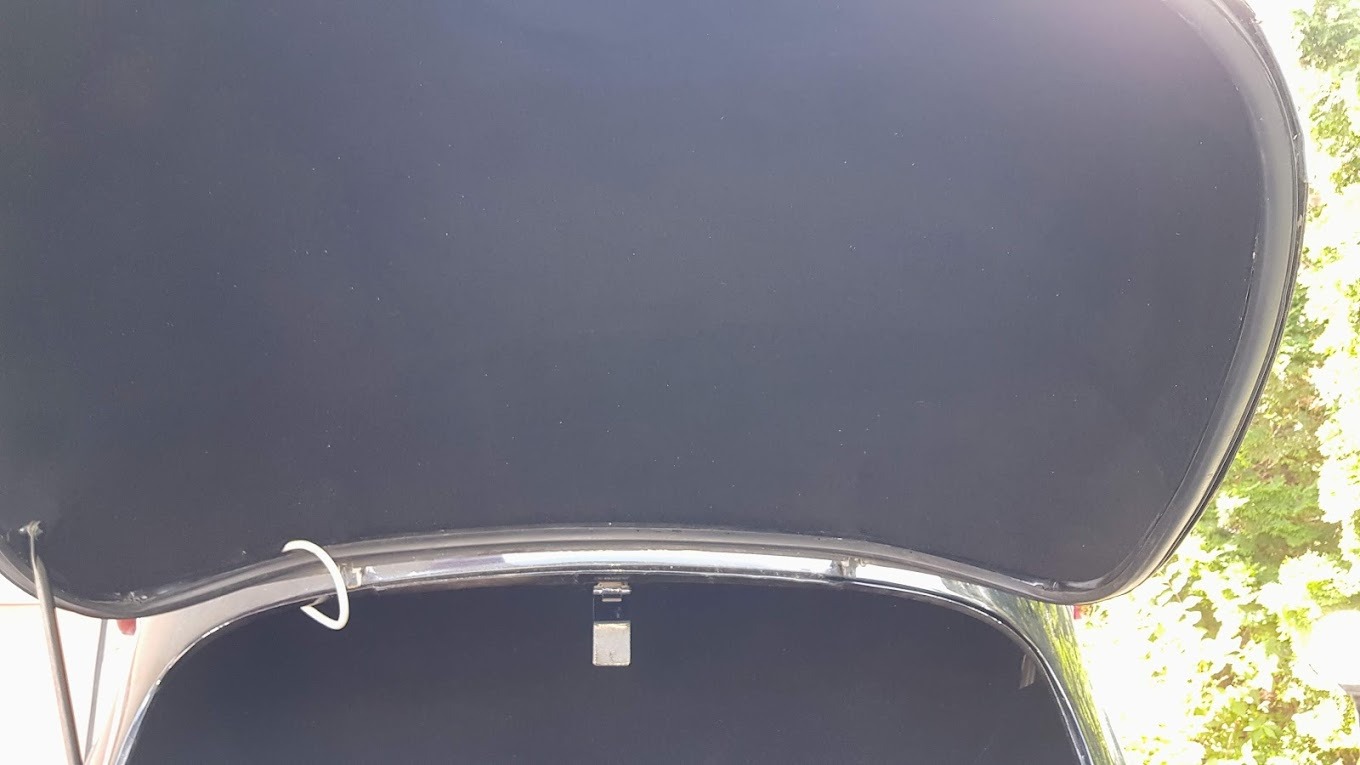 Wnętrze bagażnika samochodowego po renowacji tapicerki, widoczny nowy materiał podsufitki i elementy mocujące.