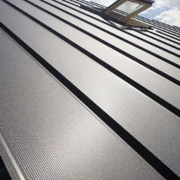 Metalowy dach panelowy z oknem dachowym, widok pod kątem, widoczne chmury na niebie.