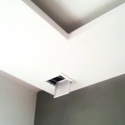 Biały sufit podwieszany z otwartym włazem rewizyjnym, ściany pomalowane w dwóch odcieniach szarości.