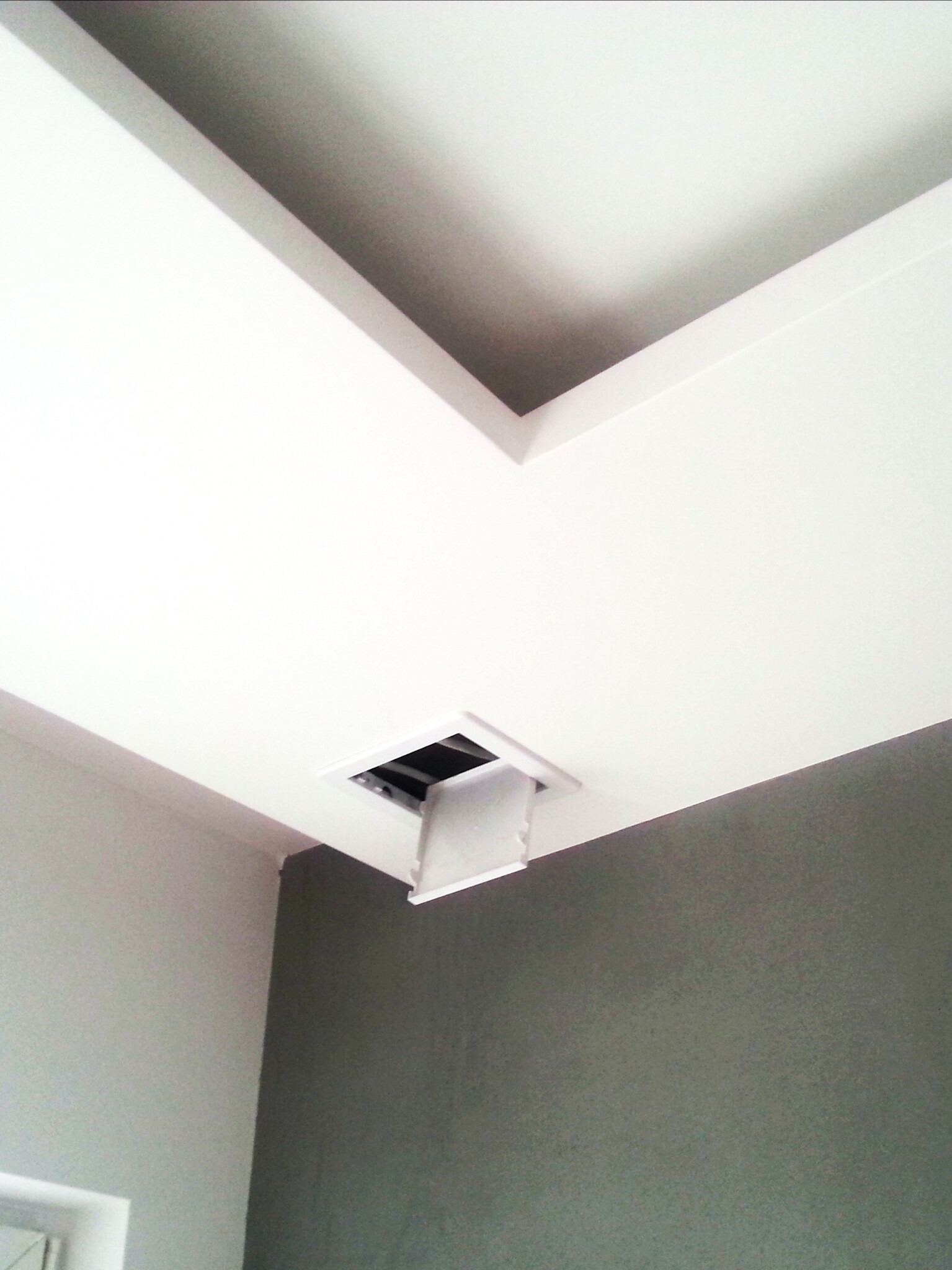 Biały sufit podwieszany z otwartym włazem rewizyjnym, ściany pomalowane w dwóch odcieniach szarości.