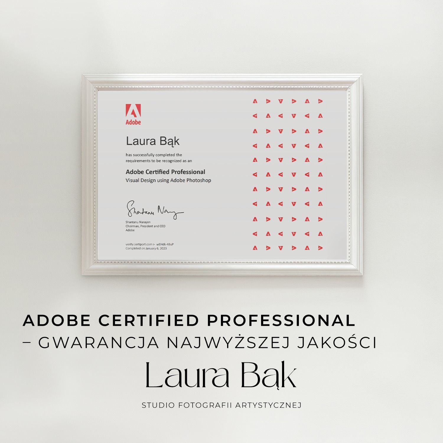 Certyfikat Adobe Certified Professional w ramce, potwierdzający kwalifikacje Laury Bąk w zakresie projektowania wizualnego w Adobe Photoshop, wiszący na ścianie nad tekstem reklamowym Studia...
