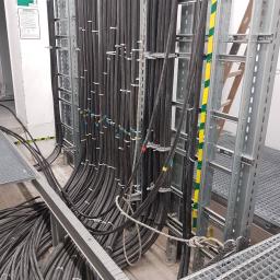 Układanie przewodów 120mm2 i 240mmm2 na trasach kablowych w budynku uczelni AGH 