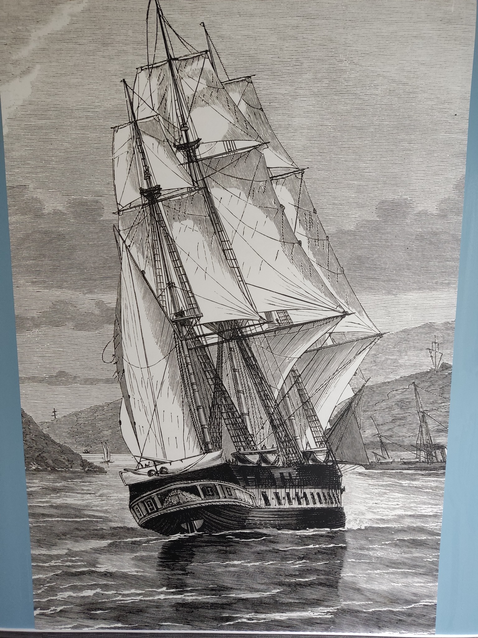 Czarno-biała grafika przedstawiająca żaglowiec na wzburzonym morzu, z widocznymi detalami olinowania, żagli i fal, zarys lądu w tle, całość utrzymana w stylu retro