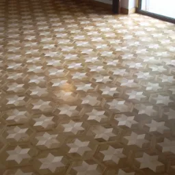 Wzór parkietu ułożonego w gwiazdy na heksagonalnym tle, widok z góry w kierunku okna.