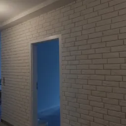 Ściana wewnętrzna wykończona dekoracyjną cegłą w odcieniach bieli, widoczna rama drzwi i fragment pomieszczenia w trakcie remontu z drabiną i wiadrem farby w tle.