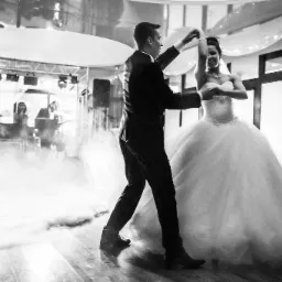 Czarno-białe zdjęcie pary młodej tańczącej w dymie, z orkiestrą w tle i fotografem po prawej.