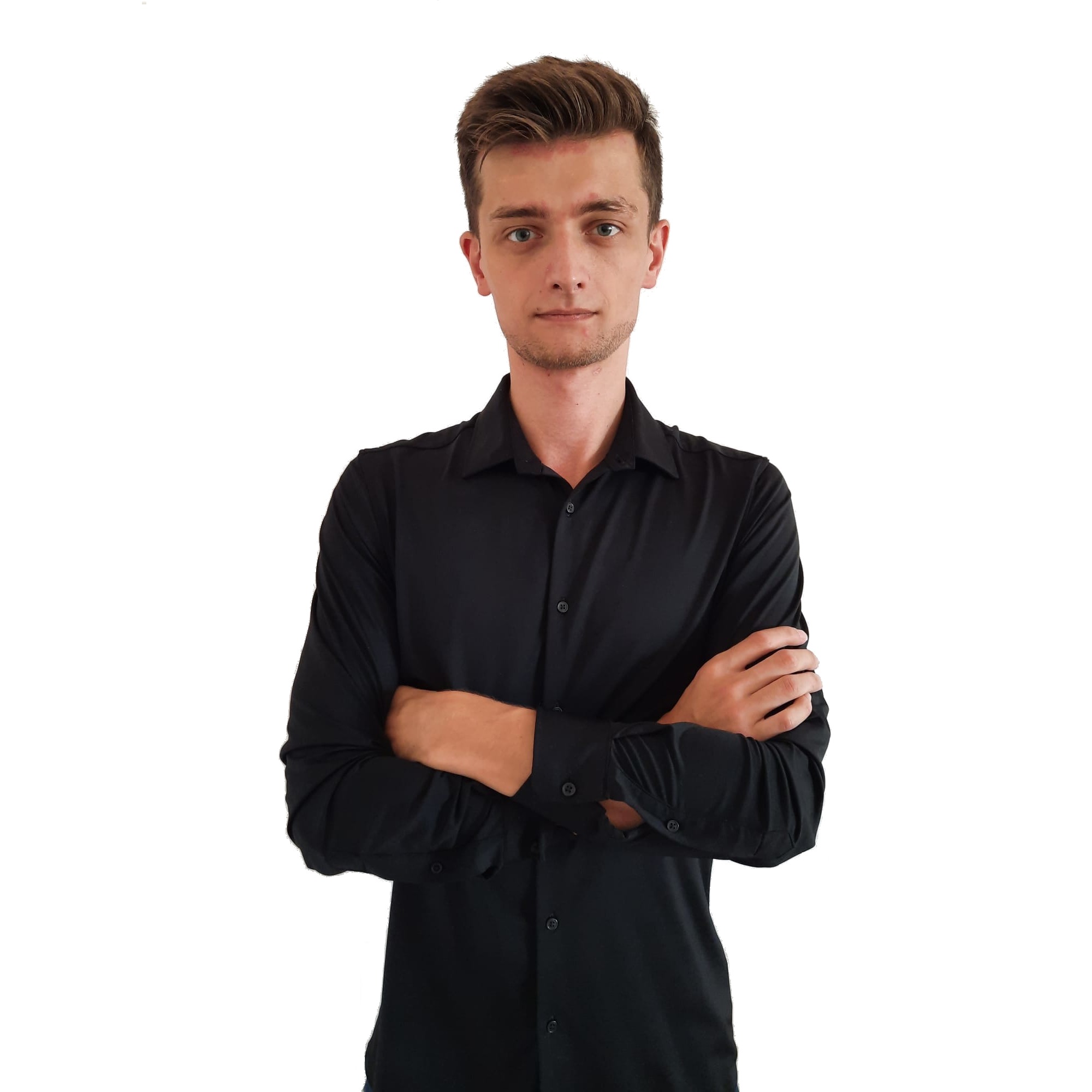 Młody mężczyzna w czarnej koszuli z długim rękawem, z założonymi rękami na białym tle, prezentujący profesjonalny wizerunek.