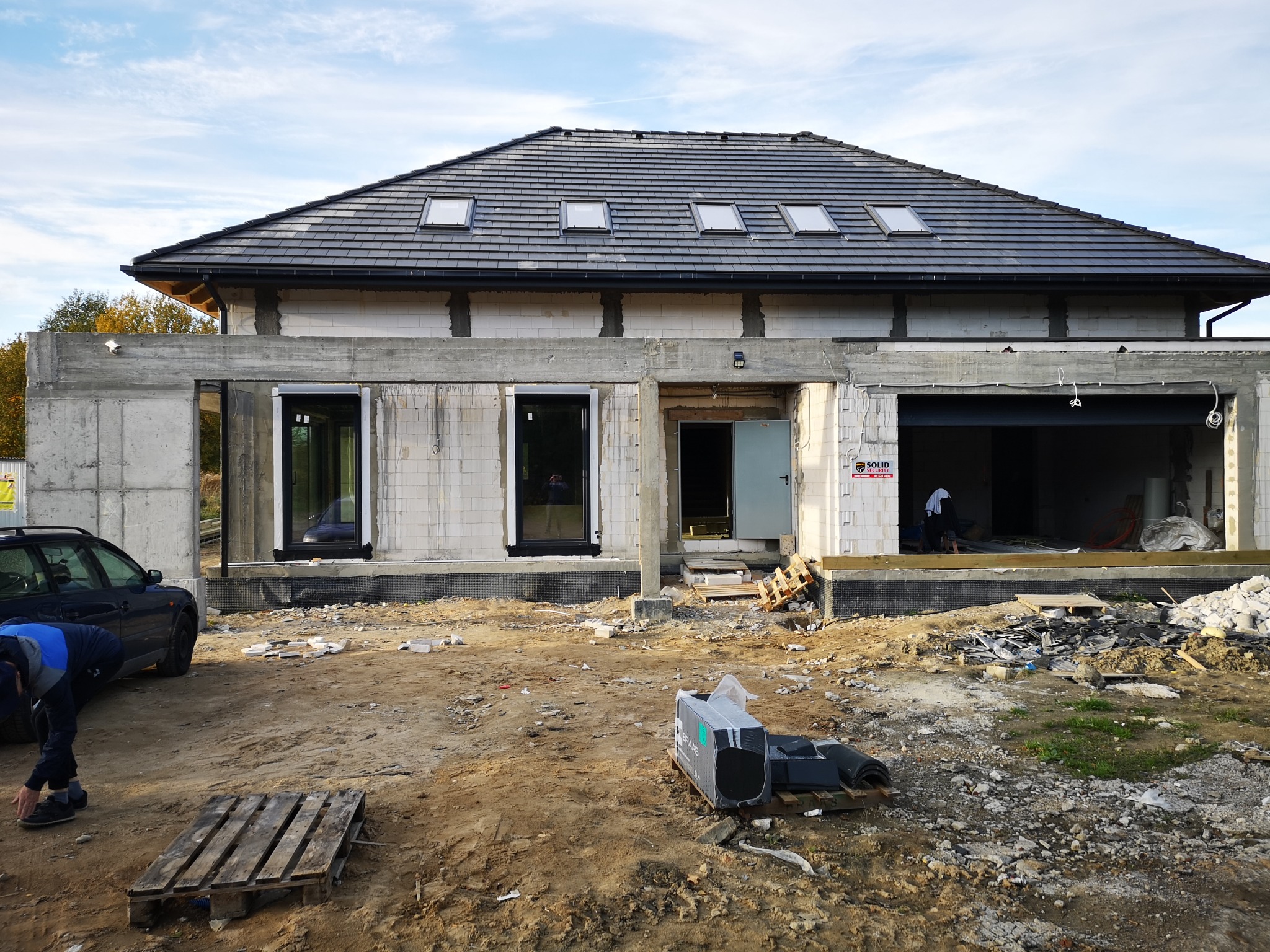 Dom w stanie surowym otwartym w Montowie, z widoczną elewacją z betonu komórkowego, czarną dachówką i oknami dachowymi, przygotowany do dalszych prac wykończeniowych.