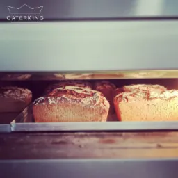 Bochenki chleba z mąką na wierzchu pieczone w piecu marki Caterking.