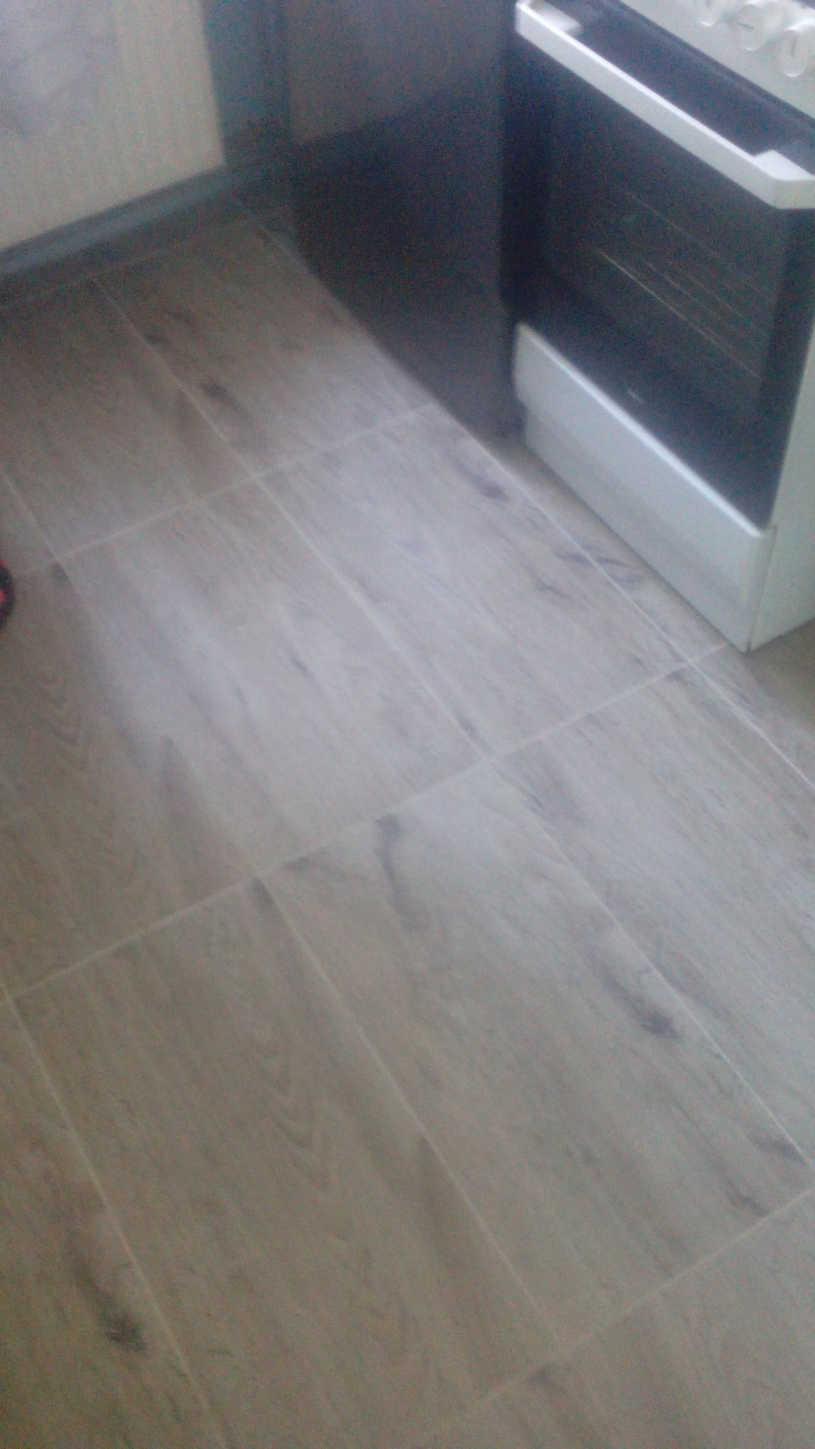 Ułożone panele podłogowe imitujące drewno w kuchni w Jamnicy, widoczny fragment kuchenki.