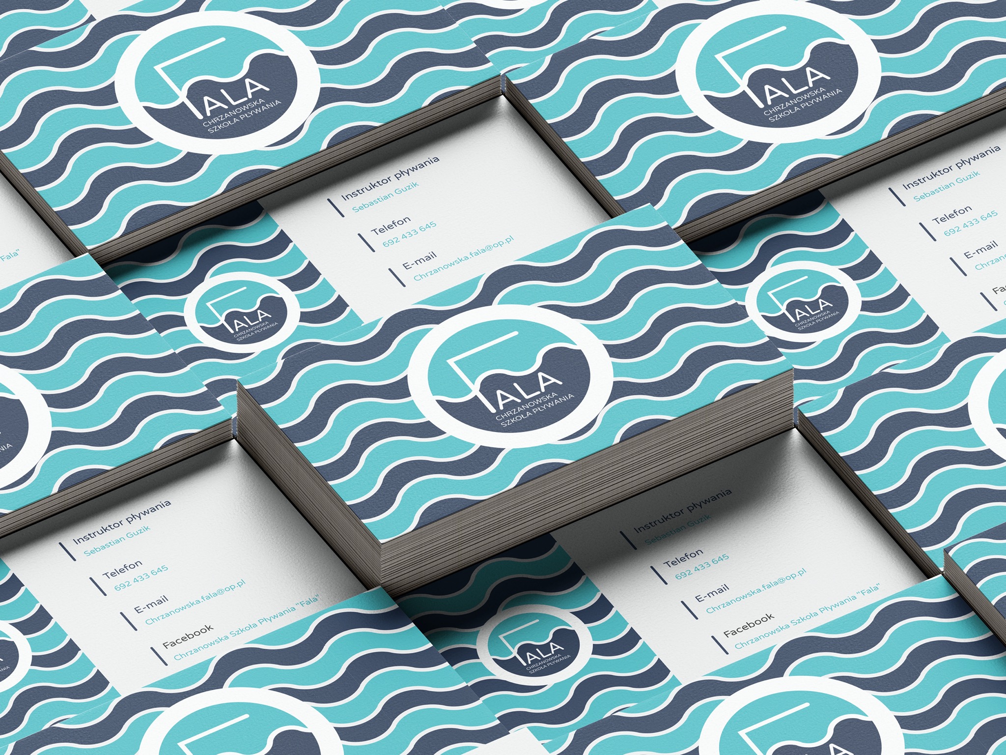 Stos wizytówek z logo i danymi kontaktowymi szkoły pływania, z motywem fal na tle.