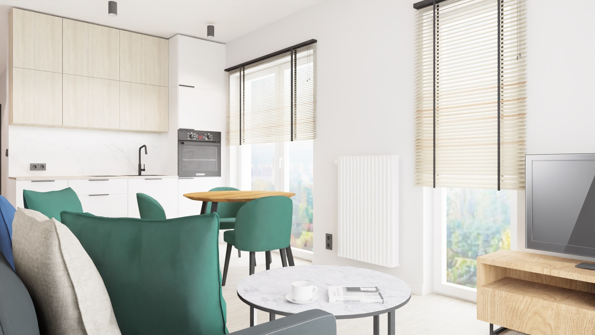 Jasne wnętrze mieszkania z aneksem kuchennym, okrągłym drewnianym stołem i zielonymi krzesłami, widok z salonu na kuchnię, białe meble kuchenne, marmurowy stolik kawowy z książką i filiżanką.