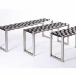 Trzy metalowe ławki o różnej długości, z ciemnymi, poziomymi deskami na siedzisku, ustawione jedna za drugą na białym tle.