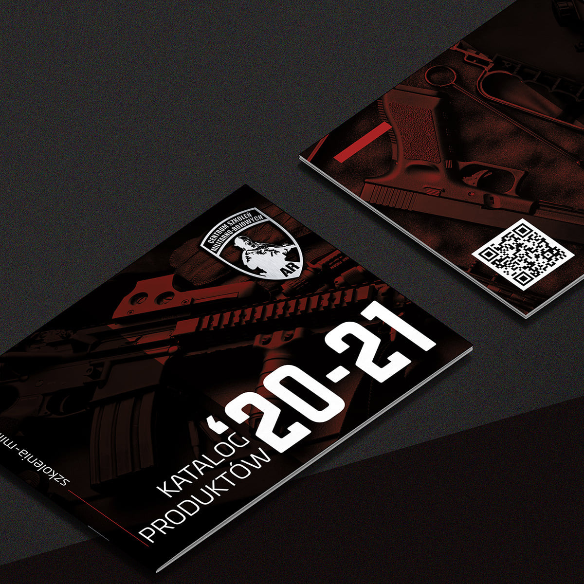 Dwa katalogi produktów w czerni i czerwieni, z logo Centrum Szkoleń Militarno-Bojowych, leżące na ciemnym tle. Katalog z Gdyni zawiera QR kod i informację '20-21'.