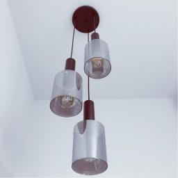 NOSTRO Jakub Izdebski - Nowoczesna lampa wisząca z trzema szklanymi kloszami w odcieniach szarości, zawieszona na czarnych przewodach i okrągłej, ciemnobrązowej podsufitce, widoczna z perspektywy żabiej z białym tłem sufitu.