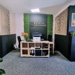 Biuro Rachunkowe PZ Twoja Księgowość - Nowoczesne biuro rachunkowe z recepcją, ścianą z mchu i logo firmy PZ Twoja Księgowość, drewnianym regałem z segregatorami i drukarką, donicami z roślinami, tablicą korkową i szarym dywanem...