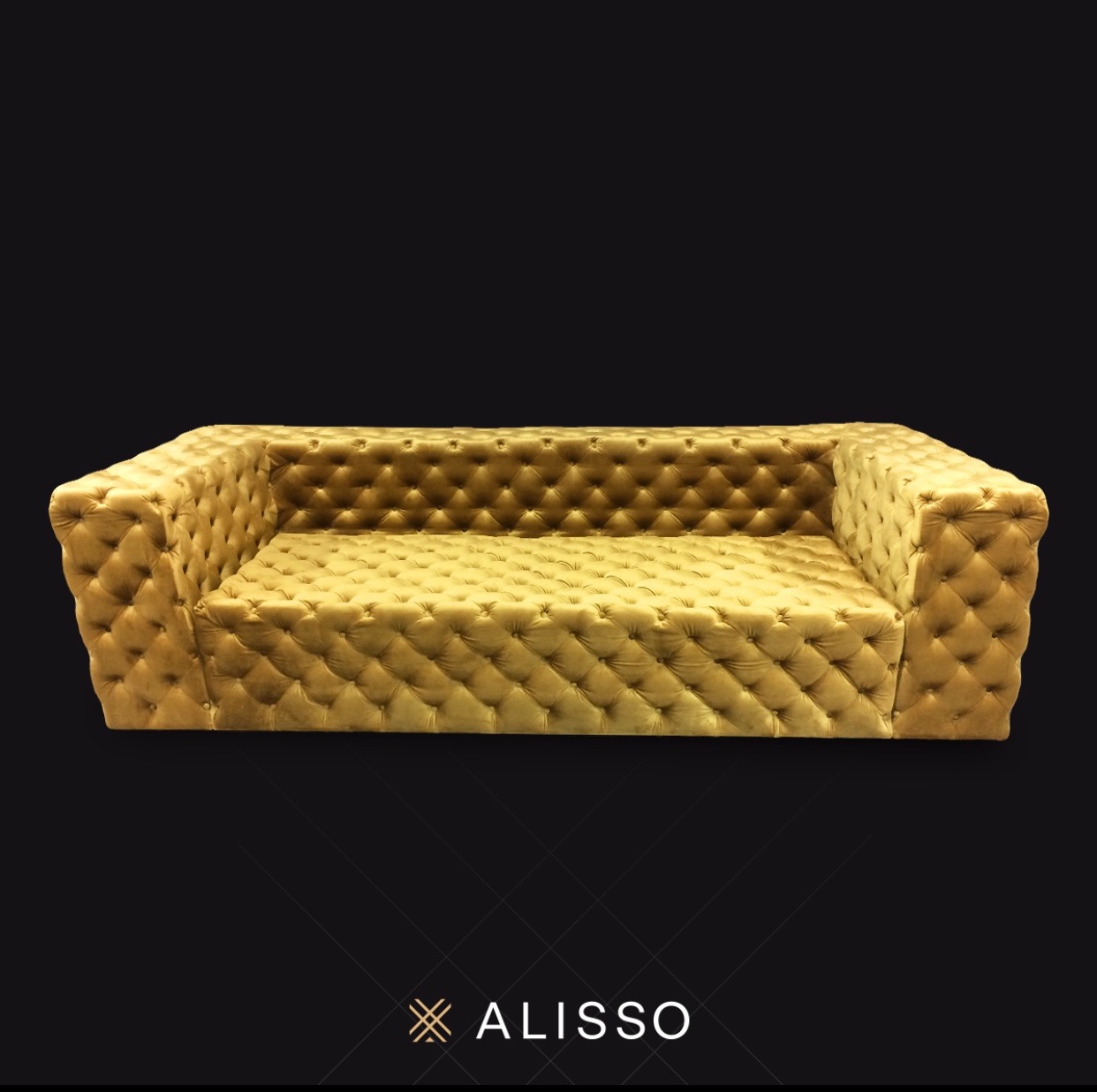 Złota, pikowana sofa w stylu Chesterfield na ciemnym tle, prezentowana przez firmę z Kalwarii Zebrzydowskiej.